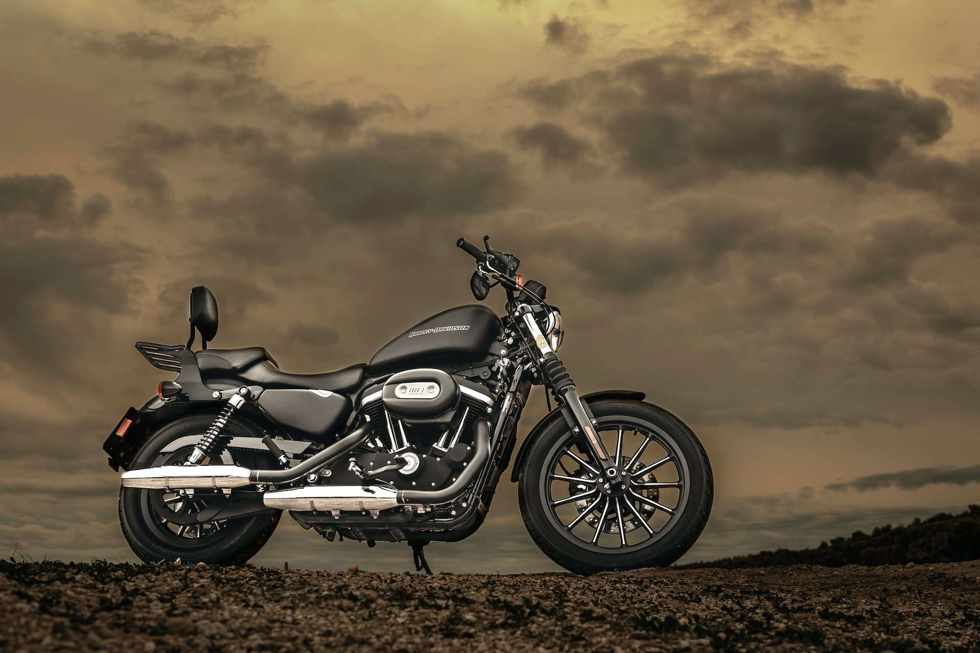 Harley-Davidson motorcycle on rocky ground against cloudy sky