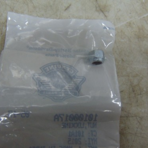 Transparent plastic bag with a faint blue logo lies on a beige work surface; a small metal cylindrical piece rests near the edge inside the bag.