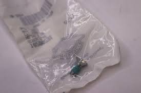 Small medical needle in sealed plastic packaging on a pale surface
