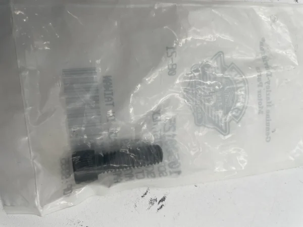 Small black threaded bolt inside a clear plastic bag with a barcode nearby