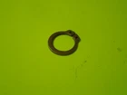 Close-up of a small black circular ring on a bright lime-green background.
