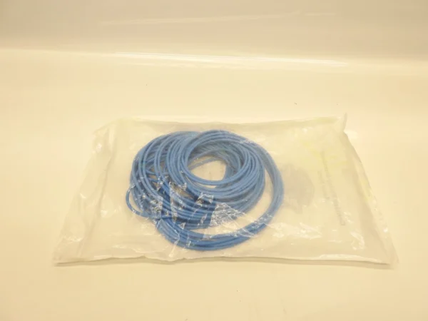 Coiled blue Ethernet network cable in a clear plastic bag on a white surface, ready for packaging or storage.