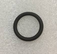 Black rubber O-ring (circular gasket) on a light speckled surface.