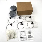 Unopened brown cardboard box with three numbered circular tokens (1, 2, 3) and small bags plus instruction sheets on a white surface.