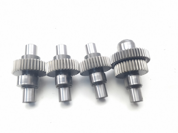 Metal shaft with four intermeshing spur gears in a row, a precision mechanical gear train.
