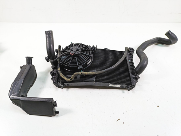26800221a | Harley-davidson® Online Automotive radiator with cooling fan and attached hoses on a white surface.