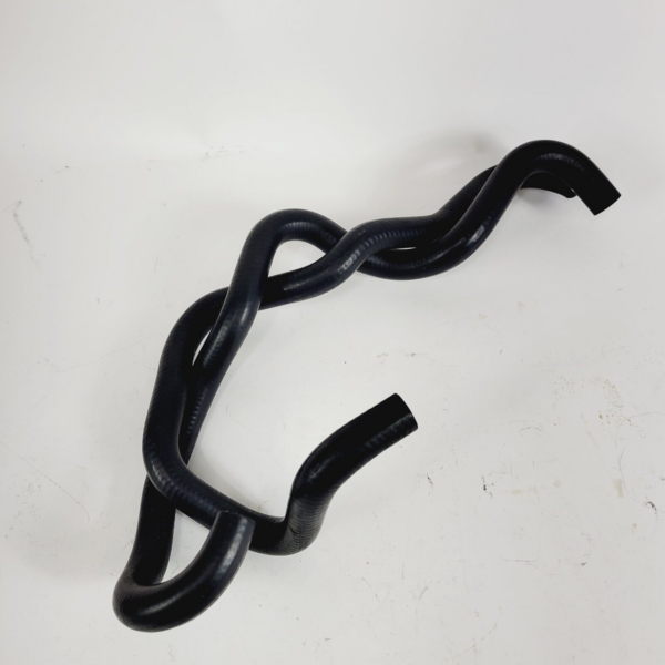 Black flexible rubber hose twisted into loops on a white surface, showing multiple curves and bends.