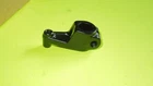 Small black metal clamp-like bracket on a bright lime-green surface.