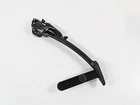 Black guitar capo resting on a white surface.