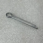 Metal R-clip (hairpin cotter pin) lying on a speckled gray surface.