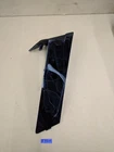 Black jagged glass shard on a pale surface with blue reflections and a small blue label underneath.