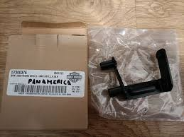 Black metal mounting bracket in a plastic bag beside a Pan America box.