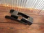 Small black tool with a metal clip resting on a wooden surface (workbench).