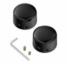 Two black round knobs with holes, an L-shaped hex key, and two small brass screws on a white background.