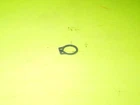Small metal key ring on a bright lime-green background on a surface.