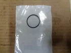 Small white package on brown surface with a black circular seal near the center.