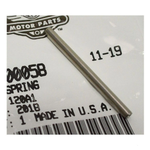 Close-up of a silver metal rod resting diagonally on a white tag showing MADE IN U.S.A., 11-19, a barcode, and a Motor Parts logo.