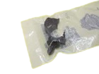 Small, transparent plastic bag with yellowish edges containing dark, irregular fragments.
