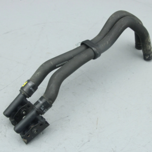 Black rubber automotive hose assembly with metal clamps and a U-shaped bend, placed on a light surface.