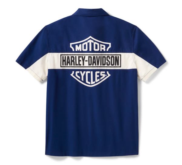 Back view of a blue Harley‑Davidson shirt with a white horizontal stripe and bold Harley‑Davidson/MOTOR CYCLES logos across the back.