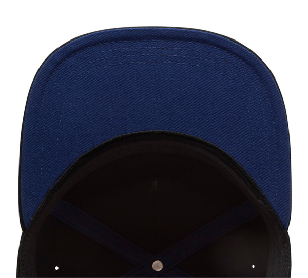 Blue baseball cap viewed from above, showing the inside of the brim and stitching along the edge of the cap surface and crown seams.